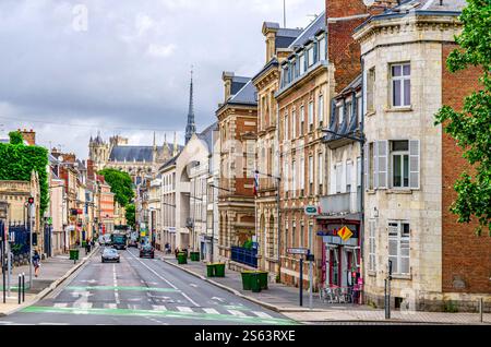 Amiens, Frankreich, 3. Juli 2023: Straßenblick auf das historische Stadtzentrum mit alten Gebäuden, Reitfahrzeugen und der Basilika unserer Lieben Frau von Amiens R. Stockfoto