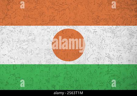 Niger-Flagge in hellen Farben auf alten Reliefputzwänden aus nächster Nähe dargestellt. Strukturiertes Banner auf rauem Hintergrund. Die Niger-Flagge ist hell dargestellt Stockfoto