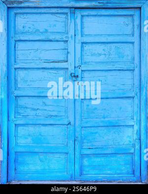Alte hellblaue kanarische Tür aus Holz mit rostigem Vorhängeschloss Stockfoto