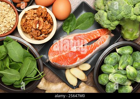 Verschiedene frische Produkte reich an Melatonin auf Holztisch, flach gelegt Stockfoto