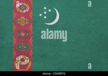 Turkmenistans Flagge in hellen Farben auf alten Reliefputzwänden aus nächster Nähe dargestellt. Strukturiertes Banner auf rauem Hintergrund. Flagge Turkmenistans Stockfoto