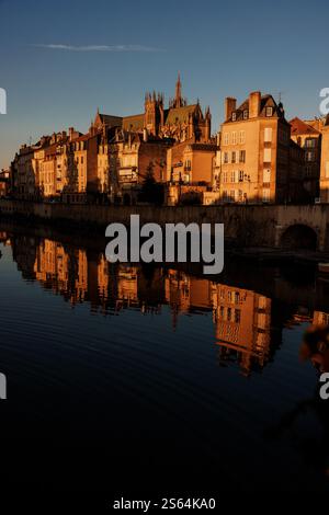 Golden Hour Stadtbild mit historischen Gebäuden, die sich in ruhigem Flusswasser spiegeln. Stockfoto