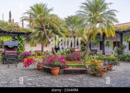 Antigua Guatemala, Sacatepequez, Guatemala. Bänke und Blumen auf einem kleinen Stadtplatz in Antigua Guatemala. Stockfoto