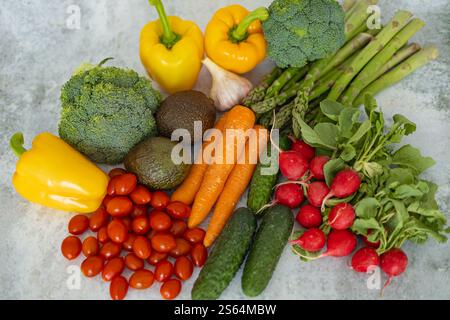 Blick von oben auf frisches, farbenfrohes Gemüse auf grauem Hintergrund. Konzept der gesunden Ernährung, Bio-Produkte und pflanzlichen Ernährung Stockfoto