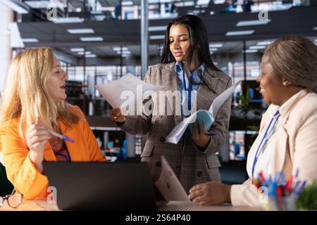 Multiethnische Unternehmensführer, die für Unternehmenserfolg und Gleichstellung von Frauen und Männern in einer von Männern dominierten Welt strategisch arbeiten. Befähigte Führungskräfte mit Führungskompetenzen arbeiten an ihrer Erfolgsgeschichte. Stockfoto