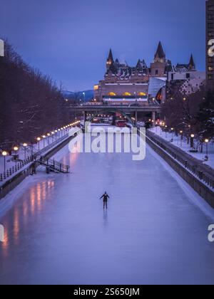 Skater auf dem gefrorenen Rideau Canal mit Chateau Laurier im Winter Scene, Ottawa Stockfoto