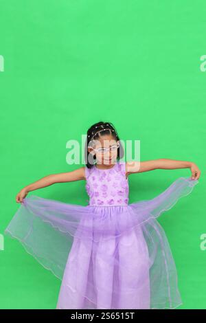 Das 5-jährige lateinische Brünette Mädchen mit Brille und Prinzessinnenkleid ist glücklich und hat Spaß beim Spielen in ihrem Urlaub Stockfoto