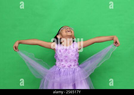 Das 5-jährige lateinische Brünette Mädchen mit Brille und Prinzessinnenkleid ist glücklich und hat Spaß beim Spielen in ihrem Urlaub Stockfoto