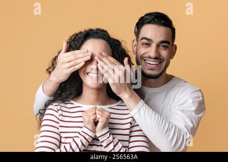 Fröhlicher Arabischer Kerl Spielt Guess Who Mit Seiner Freundin Und Bedeckt Ihre Augen Stockfoto