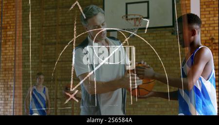 Basketballtrainer trainiert junge Spieler, Strategiebild über Szene Stockfoto