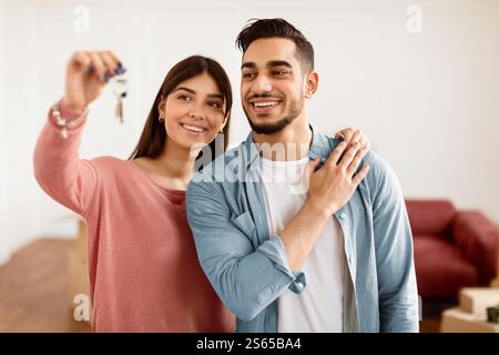 Glückliches Paar, das die Schlüssel ihrer Wohnung zeigte Stockfoto
