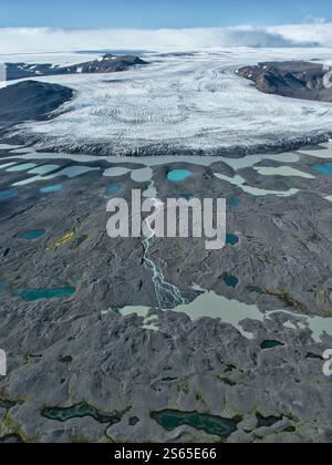 Ein atemberaubender Blick aus der Luft auf einen isländischen Gletscher, umgeben von Gletscherlagunen und zerklüfteten Landschaften, zeigt die Kraft der Kunstfertigkeit der Natur Stockfoto