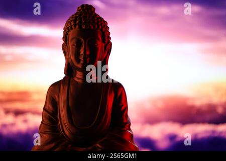 Buddha Purnima und Vesak Tageskonzept, Buddha-Statue mit dezentem Licht vor wunderschönem und farbenfrohen Hintergrund aus nächster Nähe. Meditation Stockfoto