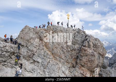 Touristen stellen sich an den Gipfel der Zugspitze, Gipfel mit goldenem Gipfelkreuz, Übertourismus, Wettersteinkette, Bayern, Deutschland, Europa Stockfoto