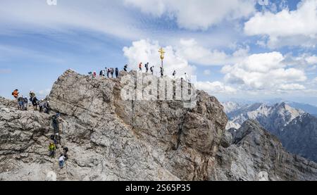 Touristen stellen sich an den Gipfel der Zugspitze, Gipfel mit goldenem Gipfelkreuz, Übertourismus, Wettersteinkette, Bayern, Deutschland, Europa Stockfoto