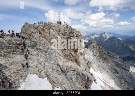 Touristen stellen sich an den Gipfel der Zugspitze, Gipfel mit goldenem Gipfelkreuz, Übertourismus, Wettersteinkette, Bayern, Deutschland, Europa Stockfoto