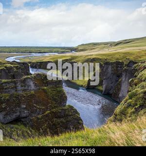 Der Fluss Fjadra fließt durch den wunderschönen Canyon Fjadrargljufur. Südisland. Bewölkter Herbsttag. Es liegt in der Nähe der Ringstraße, nicht weit entfernt Stockfoto