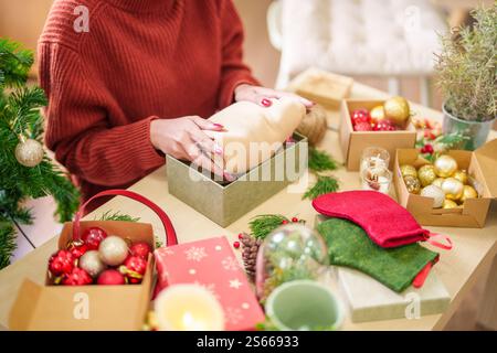 Frau im gestrickten Pullover Verpackung weihnachten Geschenke mit Öko Papier Mädchen Verpackung weihnachtsgeschenke weihnachten weihnachten Konzept. Stockfoto