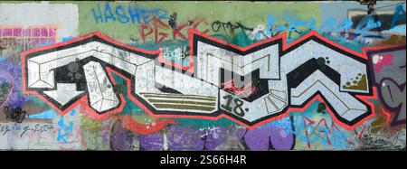 Die alte Wand, in Farbe Graffiti gemalt, mit roten Aerosolfarben. Hintergrundbild zum Thema Zeichnen von Graffiti und Straßenkunst. Die alte Mauer, Stockfoto