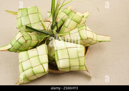 Ketupat oder Reisknödel, natürliches Reisgehäuse aus jungen Kokosblättern zum Kochen von Reis. Beliebt bei Eid al-Fitr in Indonesien. Stockfoto