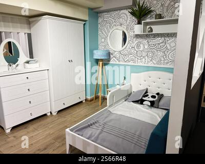 Stilvolles Kinderzimmer mit weiß-Grau-Motiven, organisierten Möbeln, verspieltem Pandastil und lebendigen Dekorationsakzenten Stockfoto