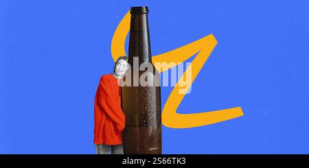 Frau, die ein rotes Sweatshirt trägt, lehnt den Kopf auf eine übergroße braune Bierflasche mit Kondensation vor leuchtendem blauem Hintergrund mit gelbem Design Stockfoto
