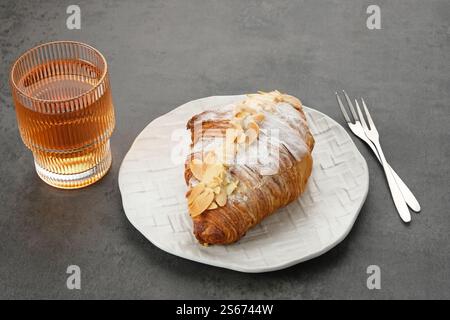 Mandelcroissant mit Puderzucker auf weißem Teller Stockfoto
