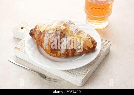 Mandelcroissant mit Puderzucker auf weißem Teller Stockfoto