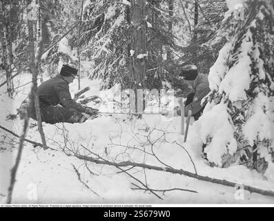 Während des Zweiten Weltkriegs. Der Krieg erschwerte den Import von Kohle für Heizhäuser und Wohnungen. Statt Kohle musste Holz verwendet werden. In Großstädten wie Stockholm konnte man große Holzhaufen entlang der Straßen sehen. Viele Männer erhielten befristete Jobs, um am Holzhacken zu arbeiten. Hier sind zwei junge Männer, die in den Wäldern außerhalb der Västmanlandstadt Skinnskatteberg arbeiten. Mit einfachen Werkzeugen wie Sägen und Äxten fielen sie die Bäume. Schweden März 1940. Kristoffersson Ref. 84-3 Stockfoto