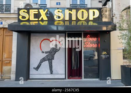 Einzigartige Storefront mit einem lebendigen Wandgemälde und Neonschildern in Paris Stockfoto