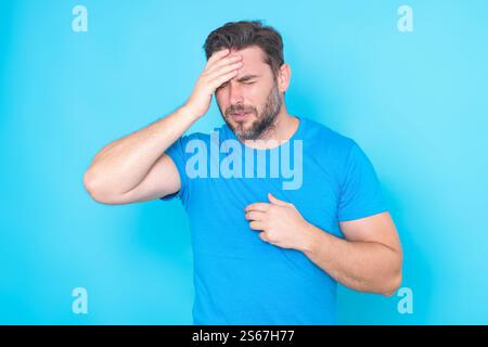 Millennial-Mann mit Kopfschmerzen. Der Mann leidet an Migräne oder Kopfschmerzen. Müder erschöpfter Mann, der an Kopfschmerzen leidet. Schreckliche Kopfschmerzen. Junger Mann in Stockfoto