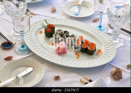 Verschiedene Sushi-Platten mit Nigiri, Rollen und Garnelen auf einer weißen Platte Stockfoto