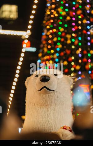Kopf eines Eisbären vor dem Hintergrund eines Weihnachtsbaums. Durchgehendes Spielzeug auf einer Party Stockfoto