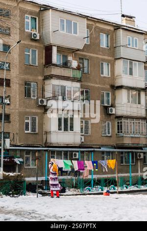 Die arme Frau hängt in kasachstan Wäsche zum Trocknen. Trocknende Kleidung auf der Straße von shymkent Stockfoto