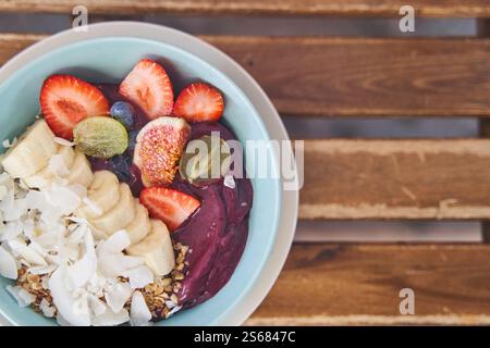 Smoothie-Schüssel mit frischem Obst, Beeren und Müsli auf dem Hintergrund eines Tisches. Stockfoto