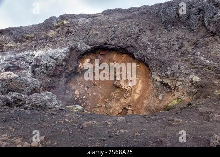 Vulkanische Felsformationen in den schwarzen Lavafeldern des Leirhnjukur-Vulkans in Island, gefrorenes Magma und dampfende Lüftungsöffnungen. Stockfoto