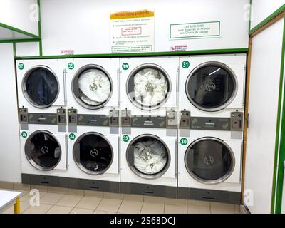 Waschmaschinen in einem Waschsalon mit Wäschetrocknung im Inneren tagsüber Stockfoto