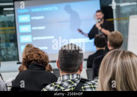 Professionelle Redner halten Geschäftspräsentationen für aufmerksames Publikum im modernen Konferenzraum. Stockfoto