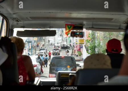 Saint George s, Grenada, Karibik - 10. Januar 2025: Blick aus einem Touristenbus auf den starken Verkehr in den Straßen von Saint George s, der Hauptstadt von Grenada in der Karibik *** Blick aus einem Touristenbus auf den dichten Verkehr in den Straßen von Saint George s, der Hauptstadt von Grenada in der Karibik Stockfoto