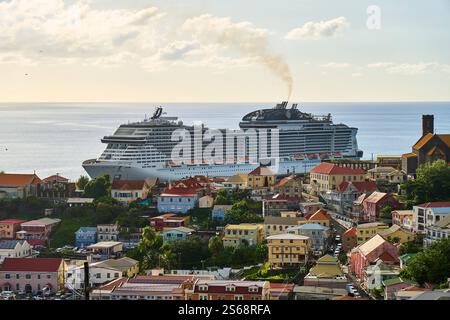 Saint George s, Grenada, Karibik - 10. Januar 2025: Blick auf das Kreuzfahrtschiff MSC Virtuosa im Hafen von Saint George s, der Hauptstadt von Grenada, mit der malerischen Karibikküste im Hintergrund *** Blick auf das Kreuzfahrtschiff MSC Virtuosa im Hafen von Saint George s, der Hauptstadt von Grenada, mit der malerischen Karibikküste im Hintergrund Stockfoto