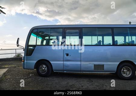 Saint George s, Grenada, Karibik - 10. Januar 2025: Ein Touristenbus wartet an einem Aussichtspunkt in der Nähe von Saint George s, Grenada, als Teil eines Ausflugs in der malerischen Karibik *** ein Touristenbus wartet auf einen Aussichtspunkt nahe Saint George s, Grenada, als Teil eines Ausflugs in der malerischen Karibik Stockfoto