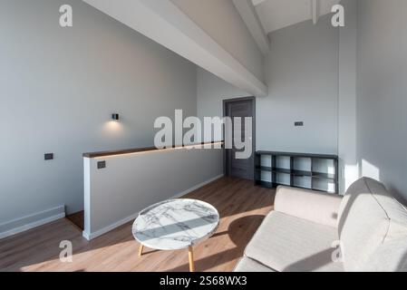 Heller, moderner Wohnbereich mit komfortablem Sofa, rundem Marmortisch, Naturholzboden und skandinavischem Design. Saubere Architektur Stockfoto