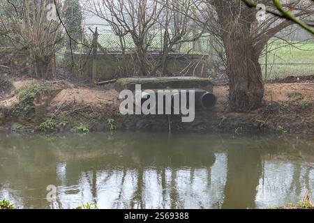 Die Enden der Abflusswasserleitungen über einem britischen Fluss an einem kalten Januarmorgen. Stockfoto