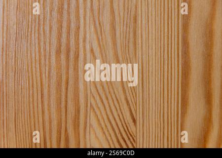 Eine Nahaufnahme einer Holzoberfläche mit natürlichem Kornmuster, die warme Töne und strukturierte Linien zeigt. Hintergründe und Texturen. Stockfoto