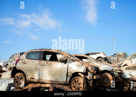 Beschädigte, mit Schlamm bedeckte Autos stapelten sich nach der DANA-Überschwemmung auf dem Benetusser-Fußballfeld. Benetusser, Spanien. Stockfoto