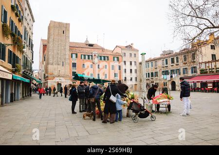 VENEDIG, ITALIEN - 14. FEBRUAR 2015: Einheimische und Touristen kaufen Blumen auf dem Straßenmarkt am Campo Santa Margherita Platz (Dorsoduro). Stockfoto