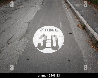 Weißes, rundes Schild auf Asphalt, das eine Geschwindigkeitsbegrenzungszone von 30 km/h in chamonix (frankreich) angibt, um die Straßenverkehrssicherheit zu fördern Stockfoto