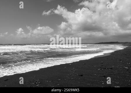 Mächtige Wellen im stürmischen Ozean, vom Sandstrand der irischen Atlantikküste aus gesehen, an windigen Tagen, in Schwarz-weiß. Stockfoto