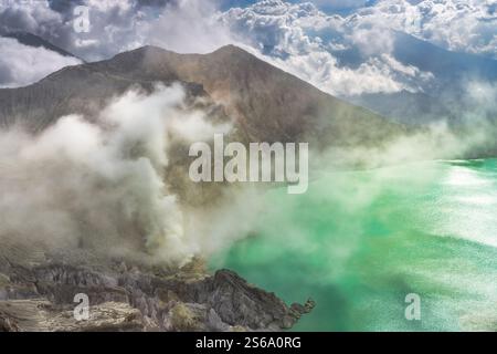 Die atemberaubende Landschaft eines vulkanischen Kratersees zeigt türkisfarbenes Wasser, das wunderschön von majestätischen Bergen im Kontrast steht Stockfoto