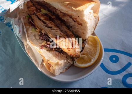 Bal?k ekmek ist ein gängiges Street Food in der türkischen Küche. Es ist ein Sandwich aus einem Filet mit gebratenem oder gegrilltem Fisch, das zusammen mit verschiedenen Gemüsesorten serviert wird, die in der Regel an Straßenständen oder Booten am Goldenen Horn oder Bosporus in Istanbul, Türkei, gekauft werden. Stockfoto